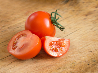 Fresh cutted tomatoes on wooden background. Harvesting tomatoes. Top view