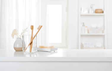 Wall Mural - Table with toothbrushes and soap inside a bright defocused bathroom