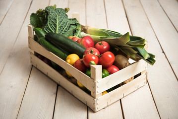 Wall Mural - Box with vegetables and fruits on a wood background from boards. Shopping, nutrition and lifestyle