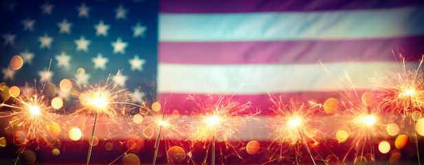 Wall Mural - Usa Celebration With Sparklers And Blurred American Flag On Vintage Background
