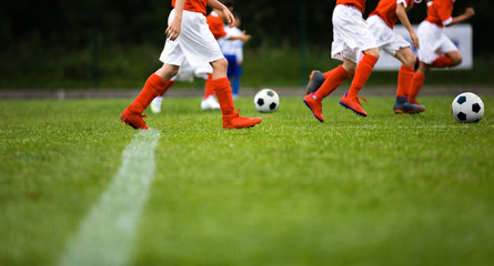 Wall Mural - Football soccer team exercising with balls. Young athletes during the team training before the match. Young players in red sportswear exercises with ball