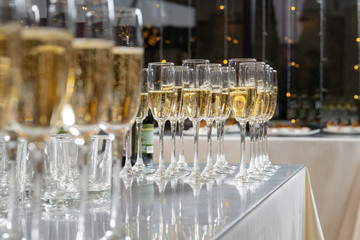 Row of glasses filled with champagne, a beautiful catering party.