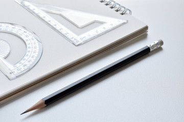 Close-up view, The desk has a black pencil, ruler and white book.