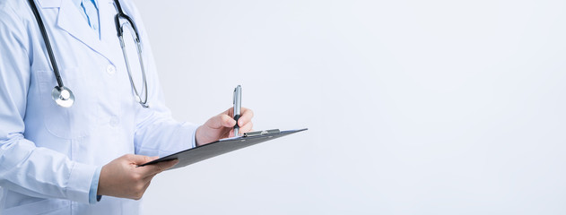 Doctor with stethoscope in white coat holding clipboard, writing medical record diagnosis, isolated on white background, close up, cropped view.