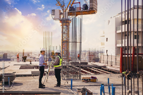 Fotomural Engineer and surveyor worker working with theodolite transit equipment at outdoors construction site