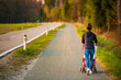 © Przemyslaw Iciak - Young mother and child in the red stroller walks outdoor in rural area before sunset.