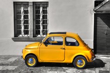 Beautiful Picture Of A Yellow Vintage Car Against A Greyscale House