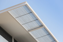 Steel Awning Of Modern House. Exterior Metal Louver Shading Against Blue Sky.