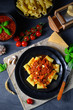 Rigatoni pasta with Bolognese sauce and fresh basil
