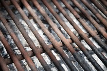 Closeup Shot Of A Rusty Metal Barbecue Grill Over The Ashes