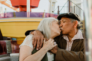 Wall Mural - Happy senior couple kissing on a Ferris wheel