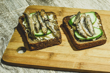 Wall Mural - toast with sprats on a wooden Board