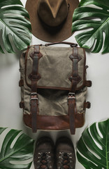 Wall Mural - explorer backpack, hat and shoes on tropical abstract background