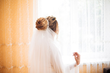 bride in white dress posing while preparing for the wedding ceremony