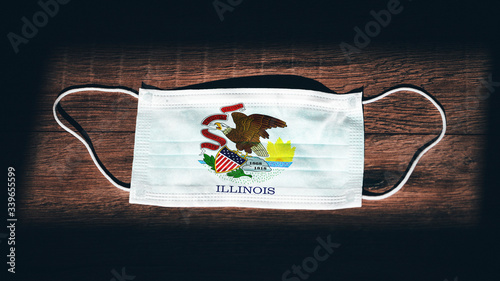 Illinois Flag. Coronavirus Covid 19 in U.S. State. Medical mask isolate on a black background. Face and mouth masks for protection against airborne infections in USA, America