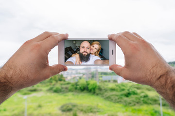 A couple takes a photo from the window of their house