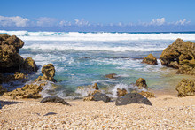 The Clear Blue Waters Of The Pacific Ocean Splashing Onto The Rocky Shoreline Of Oahu In The Hawaiian Islands.