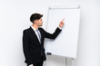 © luismolinero - Young businessman giving a presentation on white board giving a presentation on white board