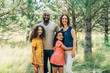 © Inti St. Clair - Portrait of smiling mixed race family with two daughters outside