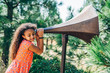© Inti St. Clair - Girl in park listening to sounds on giant megaphone