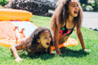© Inti St. Clair - Girls playing on slip and slide in front yard of home