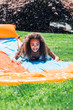 © Inti St. Clair - Girls playing on slip and slide in front yard of home