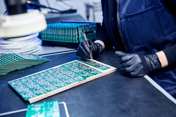Wall Mural - Engineer factory worker electronics works with a chip (board). Microchip Production, Nano computer Technology and manufacturing technological process