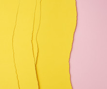 Background Of Layered Yellow Torn Paper With A Shadow On A Pink Background