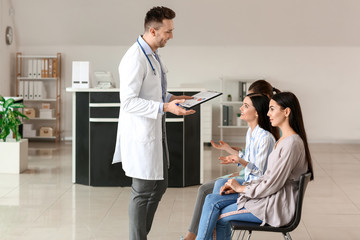 Wall Mural - Male doctor with patients in hall of clinic