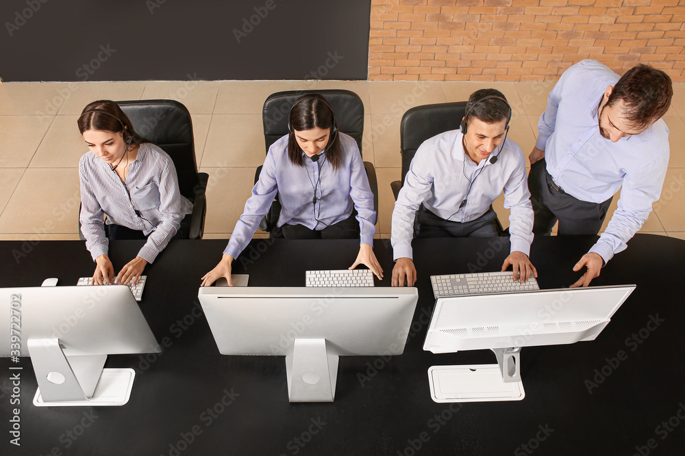 Professional technical support agent teaching young people in office, top view