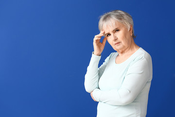 Wall Mural - Elderly woman suffering from mental disability on color background