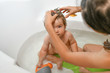 Mom washes the babys head. Joint bathing baby and mom. A symbol of cleanliness and hygiene education.