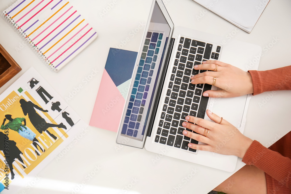 Young female designer working at home, top view