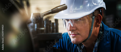 Cuadros en Lienzo industrial background of caucasian mechanics engineer operating lathe machine fo