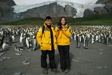 Wall Mural - Travelling Couple with Penguins in Backgound