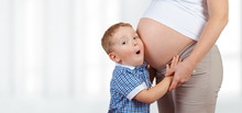 Happy Little Boy Holding And Listening Belly Of Pregnant Woman