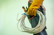 © visoot - Caucasian Electrician,Electrician with Electric cable preparing for installation in the new constructed building at construction site.
