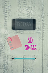 Conceptual hand writing showing Six Sigma. Concept meaning set of management techniques intended to improve business process Squared notebook marker smartphone sticky note wooden background