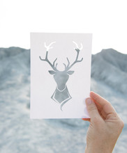 Hand Holding Perforated Paper Moose Art With Mountain Background