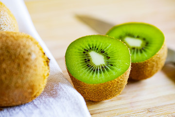 Fresh kiwifruit on wooden cutting board.