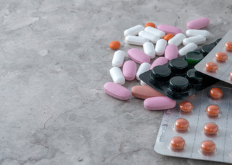 multicolored medical pills and packs of pills on a table