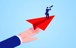 © wei wan - Giant helps businessman stand flying on paper plane and explore through telescope