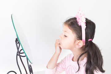 Little girl looks in the mirror before school play.