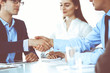 © rogerphoto - Business people shaking hands at meeting or negotiation, close-up. Group of unknown businessmen and women in modern office. Teamwork, partnership and handshake concept, toned picture