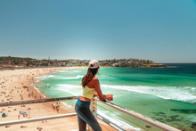 Woman At Bondi Beach, Sydney, Australia. Girl In Work Out Gear Looking At View Of The Ocean, Sun, Sea And Sand Scene, While On Vacation. Holiday, Tropical, Fitness Concepts. 