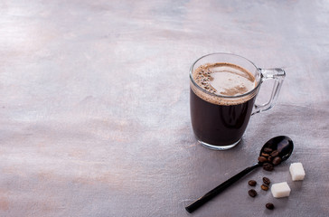 Wall Mural - Fragrant natural coffee in a glass cup, coffee aroma, sugar cubes, coffee beans, spoon