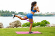 Fitness woman doing kickback exercise for glute with resistance band, outdoors. Athletic girl workout