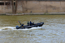 View Of The Seine River And A Black Police Boat Sailing At High Speed.