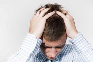 Young businessman holding head in his hands