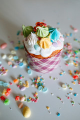 Wall Mural - Easter cake with sweet figures on the glaze, standing on the kitchen table, which is strewn with sweet ingredients